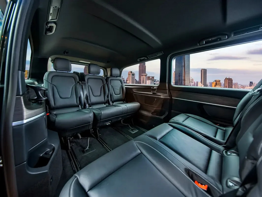 The rear cabin of a V-Class, captain's seats facing each other, city beyond the glass